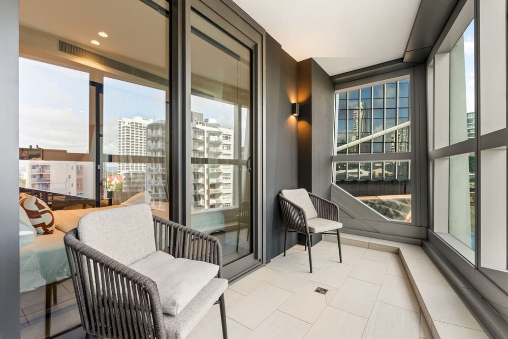 Balcony with two chairs, looking out to neighbouring towers