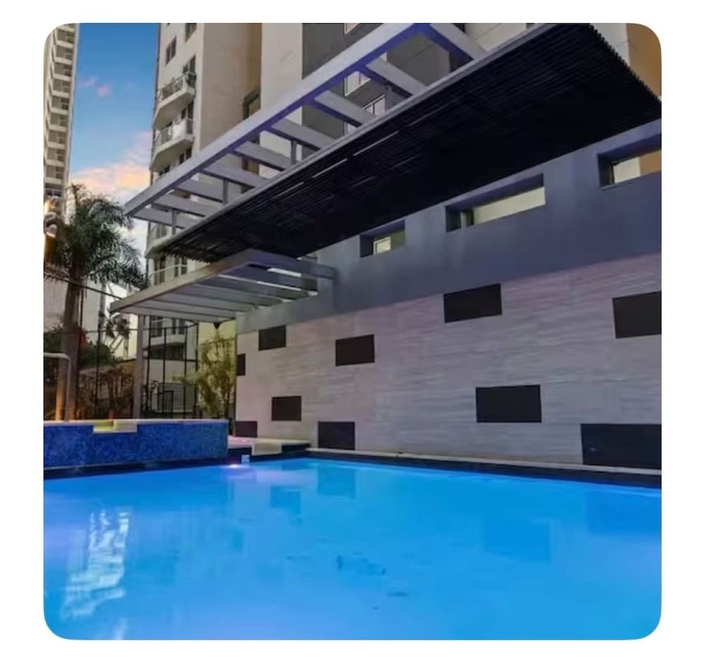 Swimming pool lit up at night beside the building